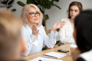 Boss speaking to employees in a meeting