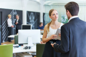 Man and woman in office talking to each other